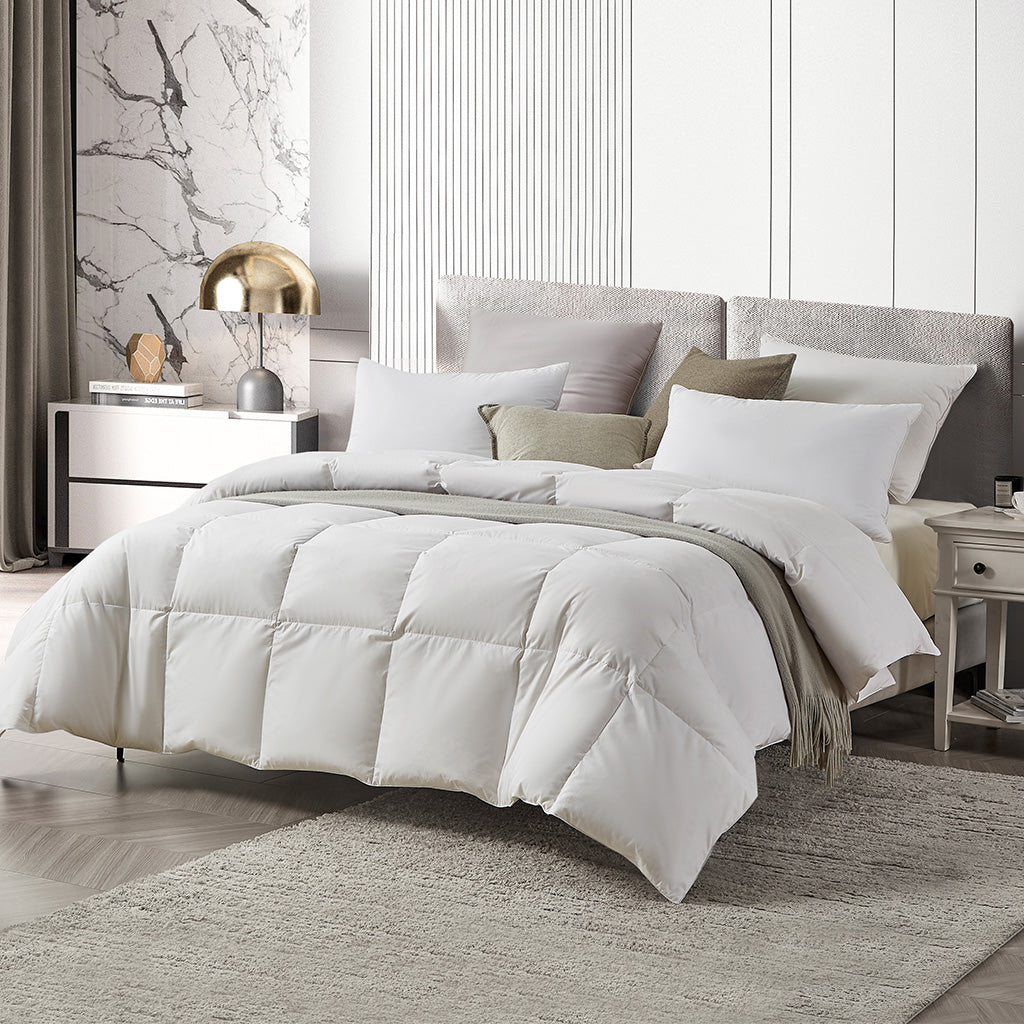 White quilt with pillows on wood bed