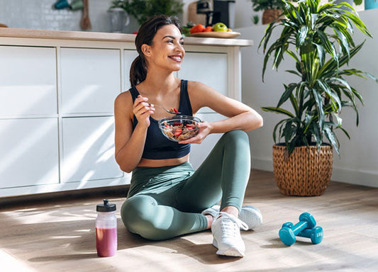 athletic woman eating healthy breakfast bowl