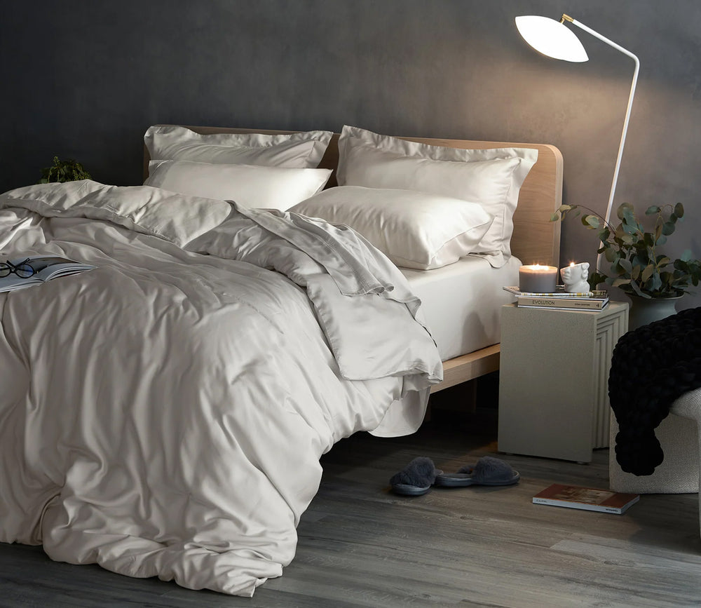 Neatly made bed with white bedding in a bedroom setting.