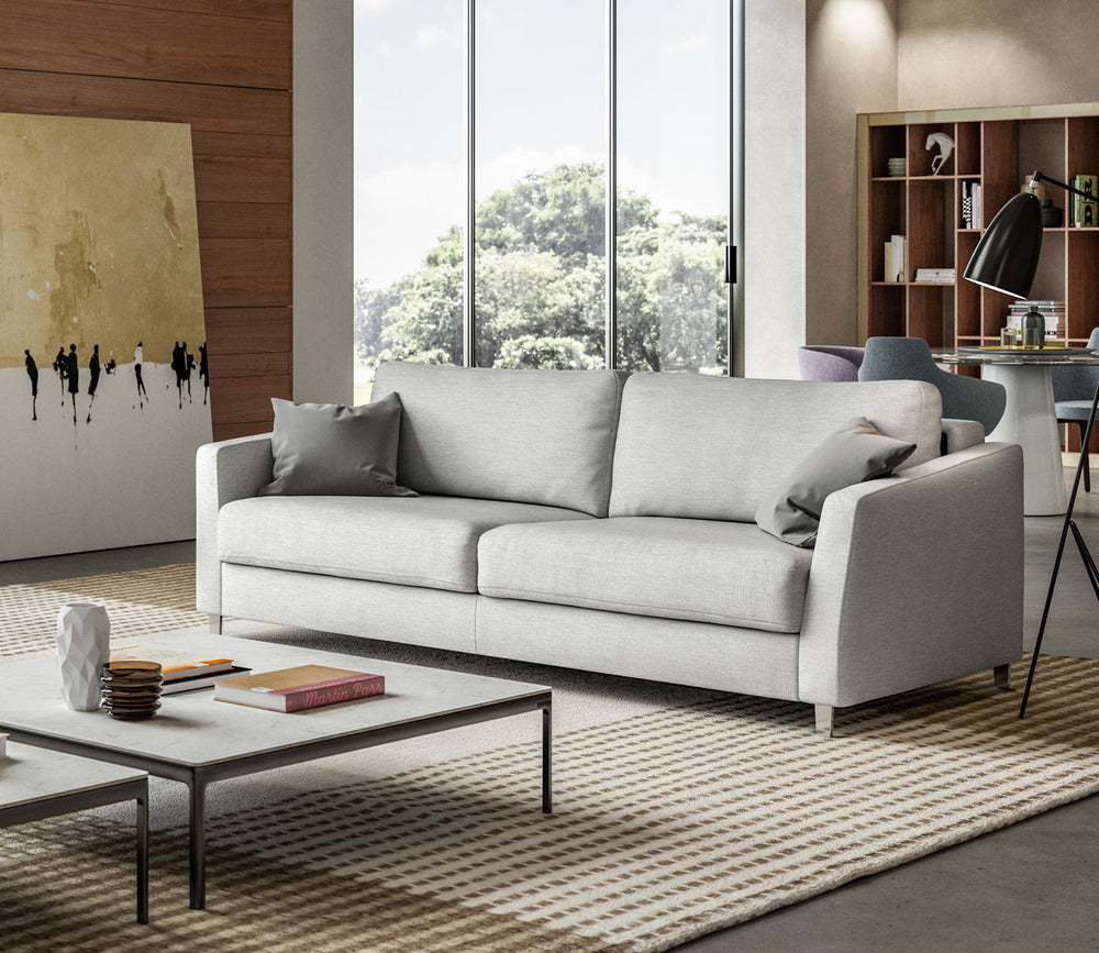 Modern living room with a gray sofa, coffee table, and bookshelf.