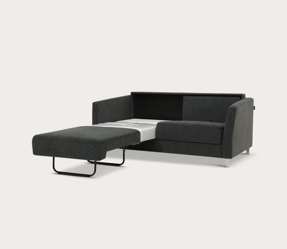 Black sectional sofa with a bed extension on a white background