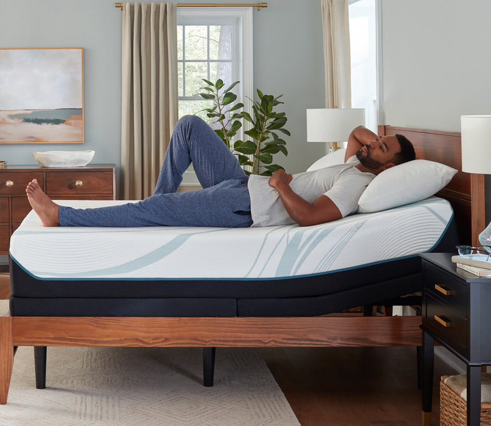 A man resting on a Tempur-Pedic mattress set on an adjustable base