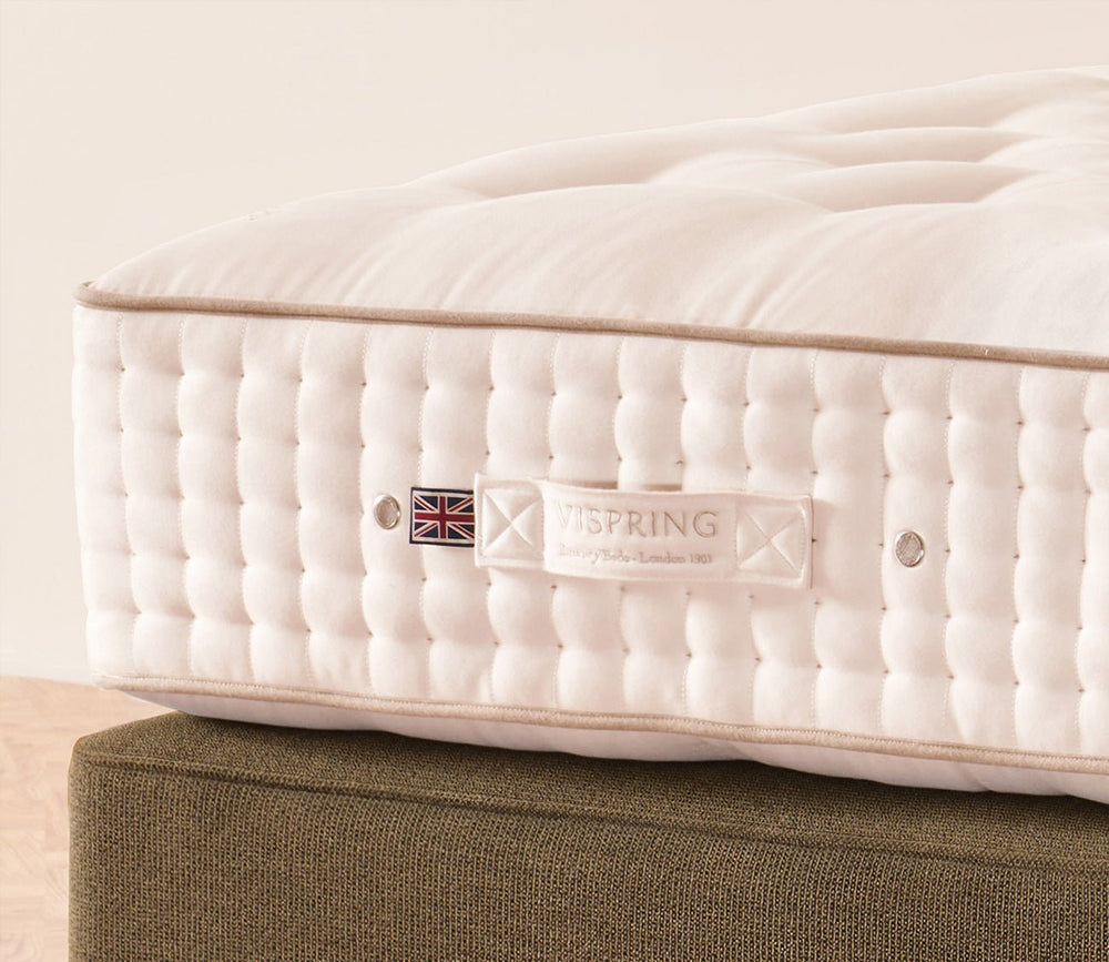 Close-up of Vispring Masterpiece Superb Mattress side panel with hand-tufted detailing and brand label.