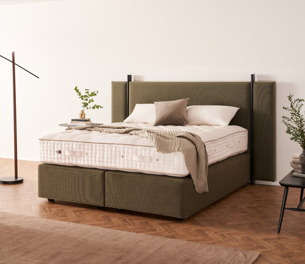 Vispring Masterpiece Superb Mattress displayed on a matching upholstered divan base in a modern bedroom with layered bedding and neutral décor.