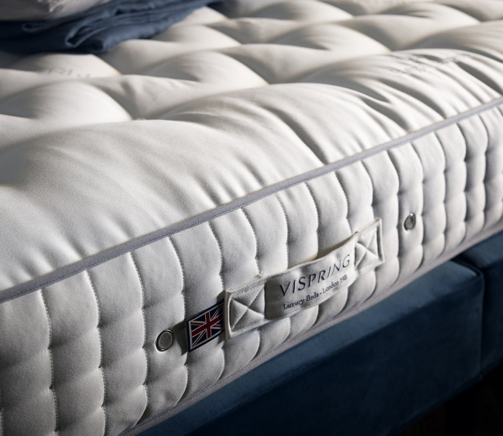 Close-up of Vispring Regal Superb Plush Mattress with a hand-tufted sleep surface and signature label.