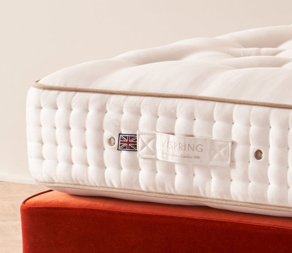 Close-up of Vispring Signatory Superb Mattress side panel with signature label and hand-tufted detailing.