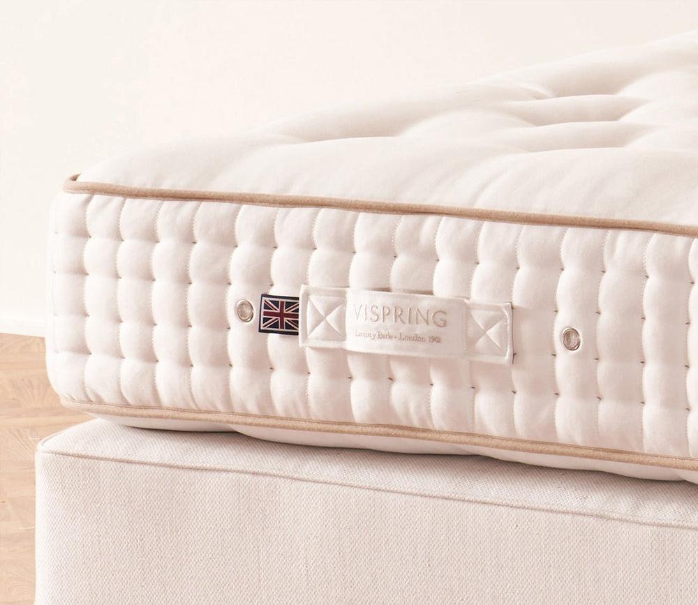 Close-up of the Vispring mattress side panel with signature label and hand-tufted finish.