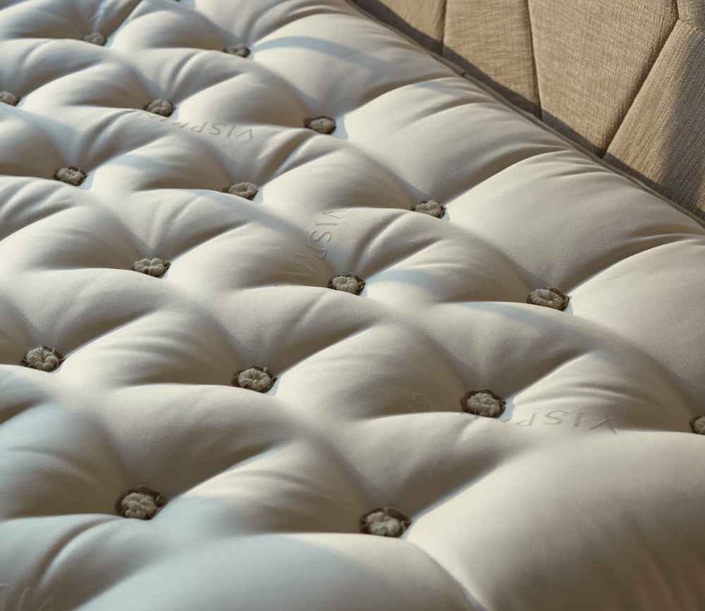 Close-up of the Vispring mattress hand-tufted sleep surface with signature wool rosettes.