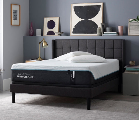 Staged room setup with a gray fabric upholstered bed supporting the TEMPUR-ProAdapt Medium Hybrid Mattress by Tempur-Pedic